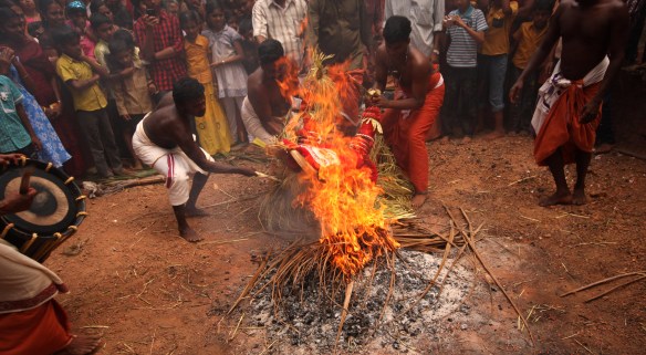 Pottan Daivan lies down on a fire